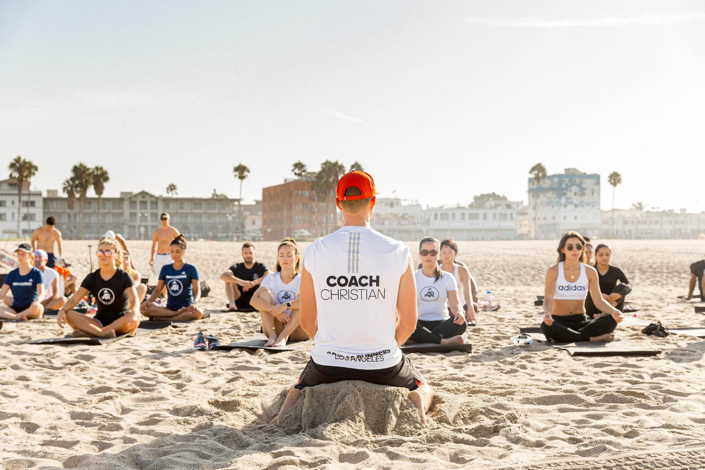 Christian Straka leading a beach meditation session with adidas Runners athletes